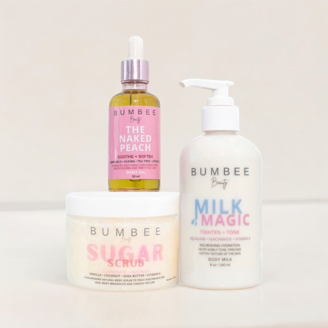 A collection of three BUMBEE beauty body care products including a body milk, body oil, and sugar scrub, with pink and peach packaging.