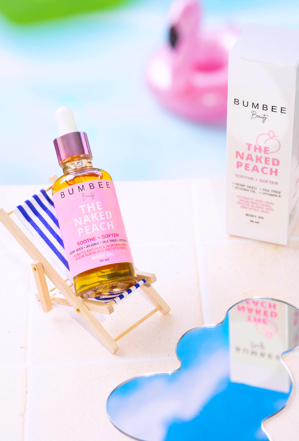Naked Peach body oil displayed against a poolside setting, highlighting its effectiveness in soothing razor burn on the bikini line. The image suggests a carefree poolside experience, emphasizing the product's ability to promote confidence and comfort in swimwear by addressing skin irritation